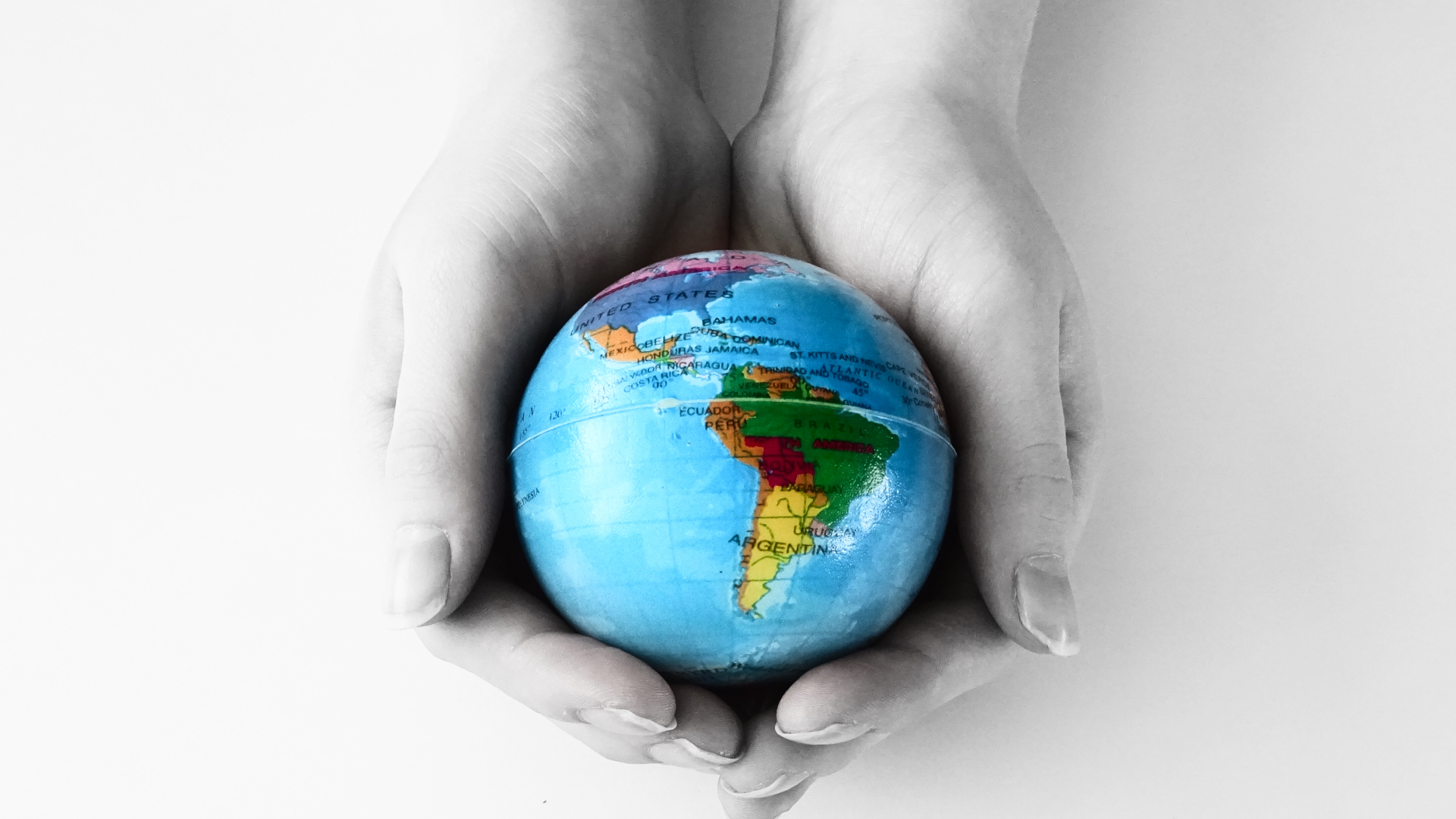 Image depicting a hand holding a globe